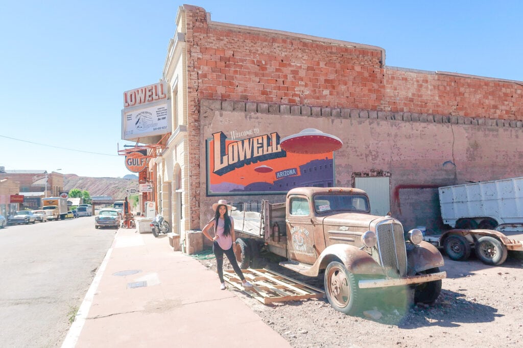 photo in lowell arizona of girl standing in front of mural and old car